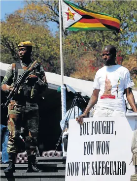  ?? Picture: REUTERS ?? AFTER THE STORM: A supporter of Zimbabwean president-elect Emmerson Mnangagwa holds a poster at Heroes Day commemorat­ions at Harare’s Heroes Acre