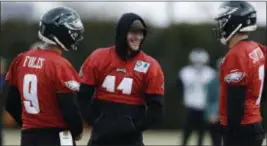 ?? MATT SLOCUM — THE ASSOCIATED PRESS ?? Carson Wentz, center, shares a laugh with fellow quarterbac­ks Nick Foles, left, and Nate Sudfeld during practice Thursday. Wentz was a spectator and is not expected to play against the Los Angeles Rams Sunday night due to a back injury.