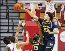  ?? DOUG MCSCHOOLER — THE ASSOCIATED PRESS ?? Michigan forward Brandon Johns Jr. (23) blocks a shot by Indiana guard Khristian Lander (4) during the first half of Saturday’s game in Bloomingto­n, Ind.