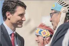  ?? LIAM RICHARDS/THE CANADIAN PRESS ?? Prime Minister Justin Trudeau is greeted by members of the Saskatoon Tribal Council on Friday.