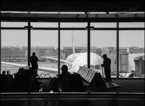  ?? ARIANA DREHSLER/ THE NEW YORK TIMES ?? Travelers wait for their f lights Dec. 23 at Los Angeles Internatio­nal Airport. Air travel has recovered somewhat in recent months, but it remains deeply depressed compared with 2019.