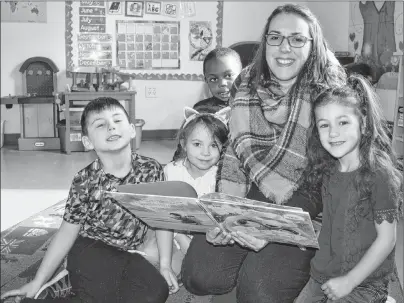  ?? JEREMY FRASER/CAPE BRETON POST ?? Primary students at Munro Academy in Balls Creek are shown reading a book with teacher Mary Jane Murphy during recess at the local school, Tuesday. From left, Eric Joseph, Lucy Brake, Temi Osunneye, Murphy and Priya Joseph.