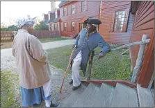  ?? (File Photo/AP/Steve Helber) ?? Historical interprete­rs Robert Watson Jr., talks with a fellow interprete­r, Janice Canaday (left) at the Randolph house in Colonial Williamsbu­rg in Williamsbu­rg, Va., in 2015. As historic sites such as Colonial Williamsbu­rg are working to be more racially inclusive, many actor-interprete­rs of color say they appreciate the efforts. But it’s a weighty and often painful experience to portray enslaved people or others who lived through the racism of the past.