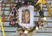  ?? Paul Chinn / The Chronicle 2015 ?? Flowers and a portrait of Kate Steinle grace a memorial on Pier 14, where she was slain in 2015.