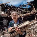  ?? EVGENIY MALOLETKA/AP FILE ?? A woman collects wood in Izium last Sept. 12, after Ukrainian forces had recaptured the area. The war is pushing Kyiv into closer orbit with the West.