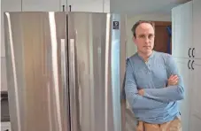  ?? PROVIDED BY RACHEL PARRISH/INSIDE CLIMATE NEWS ?? Inside Climate News reporter Phil McKenna in Cambridge, Mass., next to his new, climate-friendly Samsung refrigerat­or.
Unfounded fears, stoked by the chemical industry, led to decadeslon­g delay