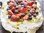  ?? AdobeStock ?? ■ A fruit-topped pavlova looks impressive, but isn’t difficult to make. This one has strawberri­es, bluebrries and passionfru­it pulp.