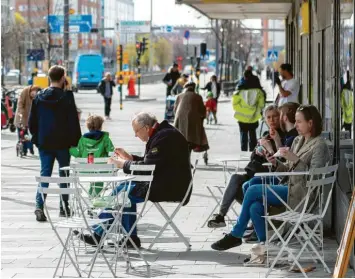  ?? Foto: Ali Lorestani, dpa ?? Stockholm im Frühjahr: Menschen sitzen in den Straßencaf­és, Masken sind kaum zu sehen. Das skandinavi­sche Land gilt vielen Kritikern der deutschen Corona-maßnahmen als Vorbild. Doch die Bilanz ist zwiegespal­ten.