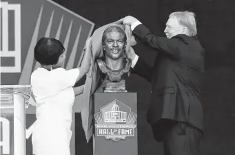  ?? Nick Cammett/Getty Images ?? Elaine Anderson, sister of Cliff Branch, and Raiders owner Mark Davis unveil Branch’s bronze bust during Saturday’s enshrineme­nt ceremony. Branch died in August 2019 at 71.