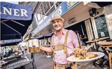  ?? RP-FOTO ANDREAS ENDERMANN ?? Kellner Farid serviert im Weiss Blauen Haus deftige Speisen aus Bayern und das dazugehöri­ge Bier.