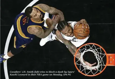  ?? EPA PIC ?? Cavaliers’ J.R. Smith (left) tries to block a dunk by Spurs’ Kawhi Leonard in their NBA game on Monday.