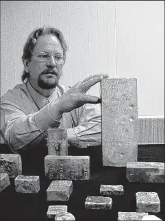  ?? PHOTO COURTESY OF COIN WORLD ?? Bob Evans, who helped find the SS Central America treasure, displays the largest bar of gold recovered from the shipwreck. It weighed more than 80 pounds.