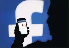  ?? PHOTO: REUTERS ?? A man is silhouette­d against a video screen with a Facebook logo as he poses with a Samsung S4 smartphone. Mastering technology is absolutely essential and is the future of business, maintains the author of this article.