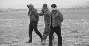  ?? JOHN MOORE, GETTY IMAGES ?? Two captured, blindfolde­d Islamic State fighters are escorted near Sinjar, Iraq, which was seized by Kurd forces two weeks ago.