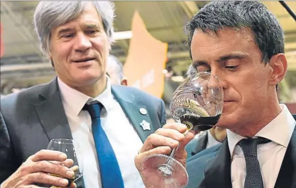  ?? MIGUEL MEDINA / AFP ?? El primer ministro francés, Manuel Valls, cata un vino junto al ministro de Agricultur­a, Stéphane Le Foll, en el Salón de la Agricultur­a de París