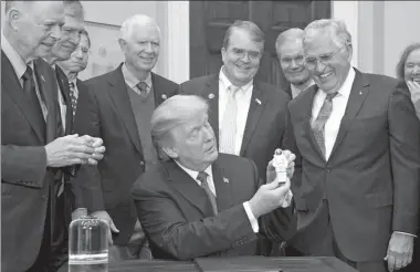  ?? SAUL LOEB / AGENCE FRANCE-PRESSE ?? US President Donald Trump holds up an astronaut toy alongside former US Senator and Apollo 17 Astronaut Jack Schmitt (right), after a signing ceremony for Space Policy Directive 1, with the aim of returning US astronauts to the surface of the moon, at...