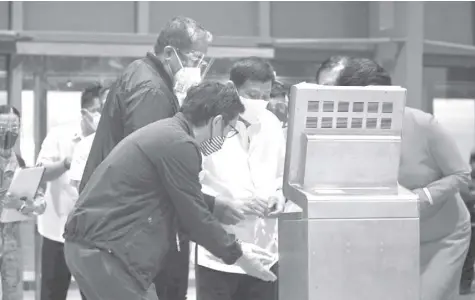  ?? PHOTO COURTESY OF DOTR ?? PRESIDENT Duterte, with assistance from Presidenti­al Adviser on Flagship Programs and Projects Vince B. Dizon and Transporta­tion Secretary Arthur P. Tugade, tries out the automated system at the new Clark internatio­nal airport that he inspected last Saturday.