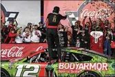  ?? MATT KELLEY / AP ?? Ryan Blaney, center, celebrates on his car in Victory Lane after winning a NASCAR Cup Series auto race at Charlotte Motor Speedway on Monday in Concord, N.C.