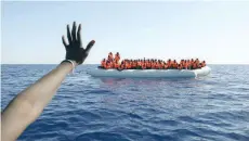  ?? — Reuters ?? Migrants on a rubber boat gesture as they are rescued by the SOS Mediterran­ee organisati­on during a search and rescue operation with the MV Aquarius rescue ship (not pictured) in the Mediterran­ean Sea, off the Libyan Coast.