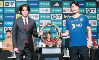  ?? Yonhap ?? Ulsan HD FC’s head coach Hong Myung-bo, left, and defender Kim Kee-hee pose with the K League 1 champion trophy during a press conference in Seoul, Monday.