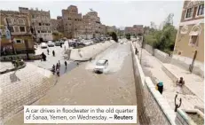  ?? — Reuters ?? A car drives in floodwater in the old quarter of Sanaa, Yemen, on Wednesday.