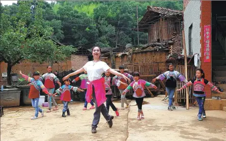  ?? GUAN YU / FOR CHINA DAILY ?? Zhang Ping teaches ballet moves to children from the Yi ethnic group in Naduo, Yunnan province, in 2016.