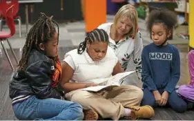 ?? ?? Fourth grader Jodacy Harris, 9, reads to Teran Horne, 11, left, teacher Jennifer Yocca and Rayne Brooks, 10.