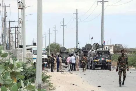  ?? — AFP ?? Somali soldiers gather at the site of a car bomb explosion which targeted a European Union vehicle convoy in Mogadishu on Monday.