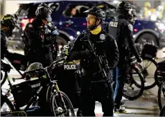  ?? TED S. WARREN/ASSOCIATED PRESS ?? Seattle police officers patrol the streets Tuesday night. Officials said several people were arrested for minor infraction­s.