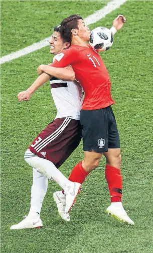  ?? EFREM LUKATSKY/THE ASSOCIATED PRESS ?? South Korea’s Hwang Hee-chan, right, battles for the ball with Mexico's Carlos Salcedo.