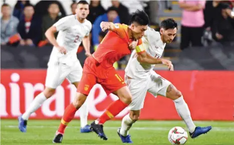  ?? (AFP) ?? China’s midfielder Zhi Zheng (centre) vies for the ball with Philippine­s’ midfielder Kevin Ingreso during the 2019 AFC Asian Cup group C match in Abu Dhabi.