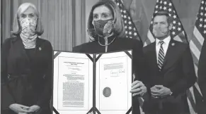  ?? ALEX BRANDON/AP ?? House Speaker Nancy Pelosi displays the signed article of impeachmen­t against President Donald Trump on Wednesday on Capitol Hill.