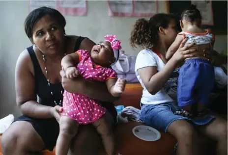  ?? MARIO TAMA/GETTY IMAGES ?? Infants born with microcepha­ly are held by mothers and family members as they attend a meeting for mothers of children with special needs.