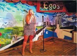  ?? LAURA J. KOSMERL VIA THE NEW YORK TIMES ?? A woman singing at Ego’s, a friendly karaoke bar of mostly locals tucked inside a parking garage in Austin, Texas.