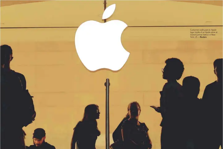  ?? — Reuters ?? Customers walk past an Apple logo inside of an Apple store at Grand Central Station in New York, US.