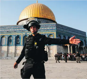  ?? AHMAD GHARABLI / AFP / GETTY IMAGES ?? A member of the Israeli security forces gestures near the Dome of the Rock in the old city of Jerusalem on Thursday.