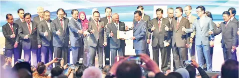 ??  ?? Shafie (front, fifth from right) and Hasim showing the State Government Key Performanc­e Index blueprint at Sabah State Administra­tive Center yesterday.