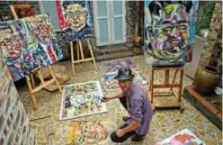  ??  ?? Vietnamese artist Tran Lam Binh poses with the portraits of US President Donald Trump and North Korean leader Kim Jong Un at a cafe in Hanoi.