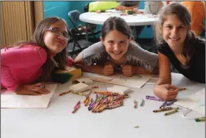  ?? Brittany Williams/News-Times ?? Earth Day: Northwest students Emma Gilbert, Layla Maza and Madyson Lonider take a break from decorating recyclable car litter bags to celebrate Earth Day.