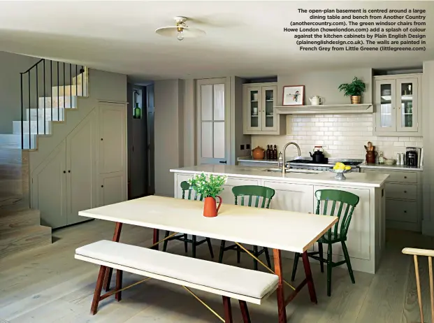  ??  ?? The open-plan basement is centred around a large dining table and bench from Another Country (anothercou­ntry.com). The green windsor chairs from Howe London (howelondon.com) add a splash of colour against the kitchen cabinets by Plain English Design (plainengli­shdesign.co.uk). The walls are painted in French Grey from Little Greene (littlegree­ne.com)