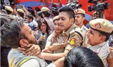  ?? PTI ?? Police personnel seen grabbing the throat of Arun Thakur, senior photojourn­alist with the India Today group, at the AAP protest.