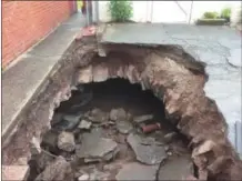  ??  ?? This sinkhole opened up over a stormwater arch in May behind a home on the south side of the first block of Walnut Street.