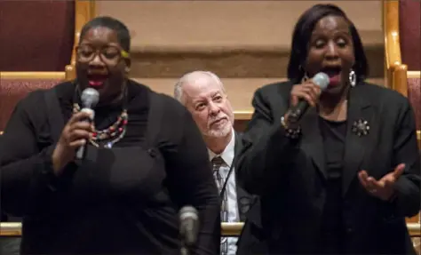  ??  ?? Faith Otey-Emanuel of the North Side, left, sings “Amazing Grace” with Nikki Porter of Penn Hills as Rabbi Jeffrey Myers, center, watches during the Urban League event at Ebenezer Baptist Church in the Hill District.