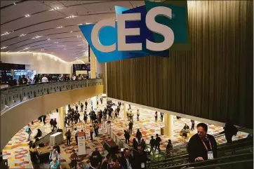  ?? Associated Press photos ?? People walk through the Venetian Expo center during the CES tech show Thursday in Las Vegas.