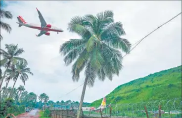  ?? AFP ?? An aircraft approaches to land, near the wreckage of the Air India Express jet, at Calicut Internatio­nal Airport on August 8. n