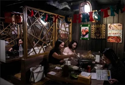  ?? ISAAC LAWRENCE
Getty Images ?? People eat at a restaurant in Hong Kong on Thursday, after the government eased some of the COVID-19 restrictio­ns.