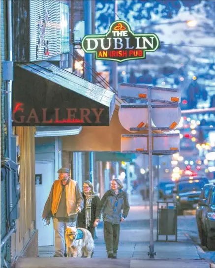  ?? Photograph­s by Mark Boster Los Angeles Times ?? THE SIGN begins to glow outside the Dublin as the sun sets on Montana Street in Butte, where Irish presence is felt all over town.