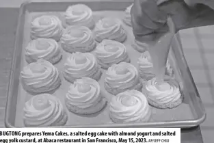  ?? AP/JEFF CHIU ?? BUGTONG prepares Yema Cakes, a salted egg cake with almond yogurt and salted egg yolk custard, at Abaca restaurant in San Francisco, May 15, 2023.