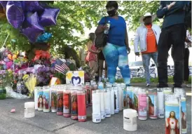  ?? USMAN KHAN/AFP VIA GETTY IMAGES ?? Candles, balloons and flowers are at a makeshift memorial near Tops Grocery store in Buffalo, New York, on Sunday, the day after an alleged racist gunman killed 10 people.