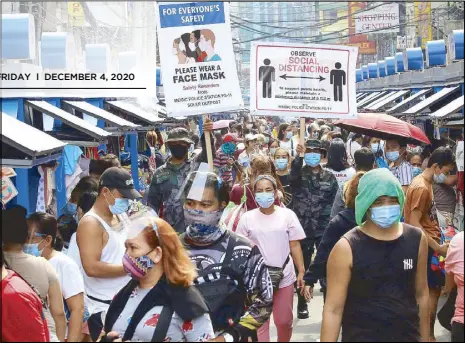  ?? EDD GUMBAN ?? Police officers patrol Divisoria in Manila to remind shoppers to wear face masks and observe physical distancing measures. At left, Mayor Isko Moreno and Health Secretary Francisco Duque walk around Divisoria with a meter stick to urge people to comply with physical distancing.